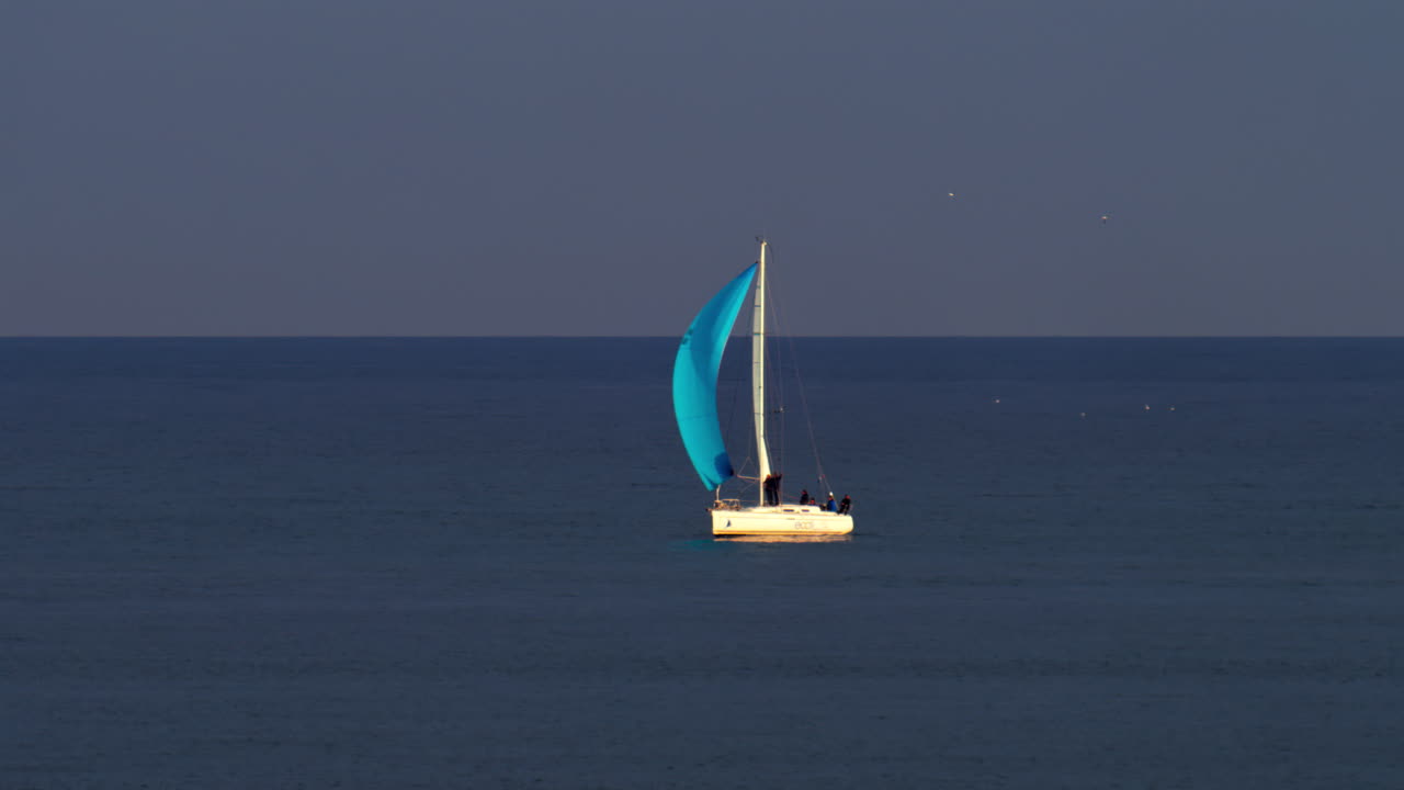 Cannes, France - March 5, 2025: People on a moving sail boat on the sea on a cloudy day