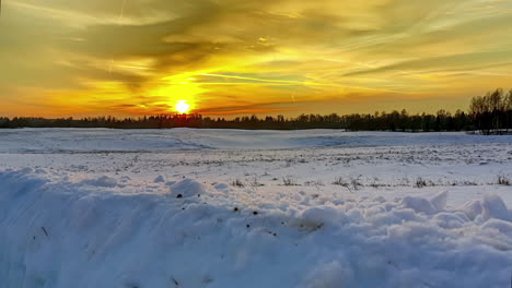 Goldener-Sonnenuntergang-über-Einem-Wald-Und-Einem-Verschneiten-Feld-–-Zeitraffer-Mit-Rückzugsbewegung