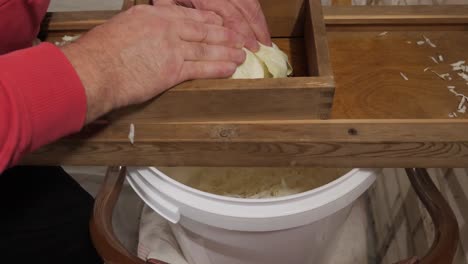 grate cabbage with old wooden grater for sauerkraut, close up