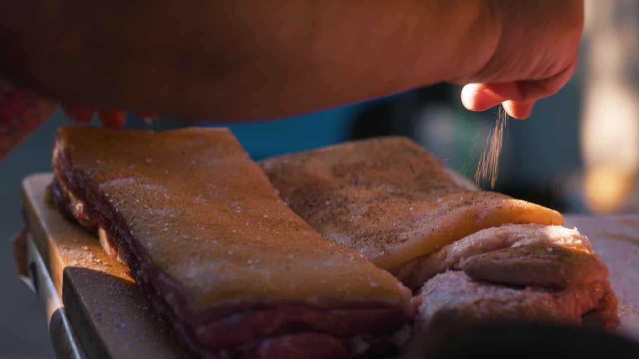 Woman prepares a piece of lard by adding spices