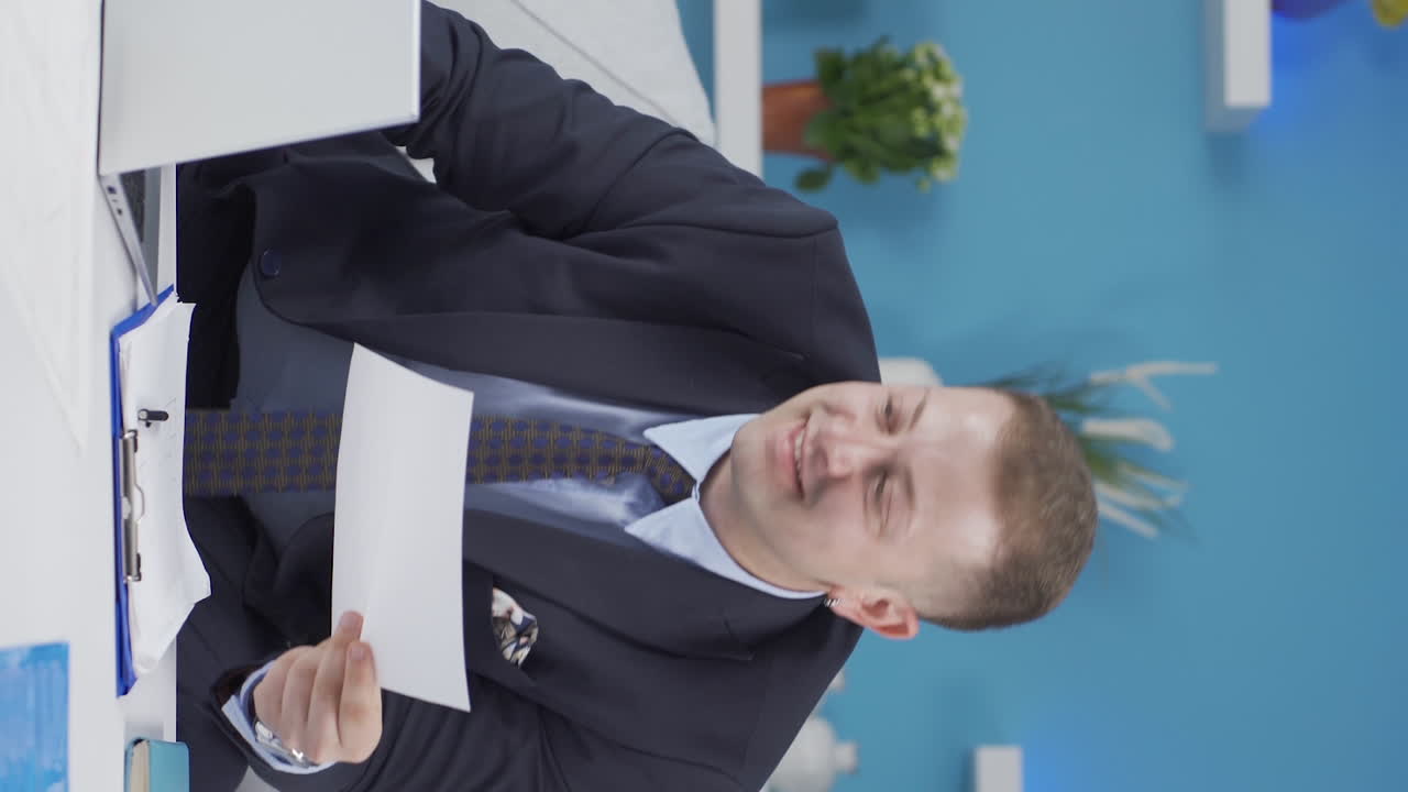 행복하고 미소 짓는 홈 오피스 직원의 수직 비디오.