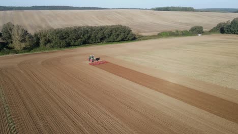 aerial view of a working tractor on a sunny day on a large field.