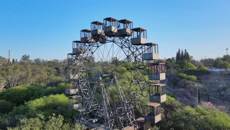 Panorámica-De-Primer-Plano-Aéreo-Alrededor-De-La-Rueda-De-La-Fortuna-De-Rueda-Eiffel-De-Hierro-Vintage-Inactiva-En-El-Parque-Sarmiento,-Córdoba,-Argentina