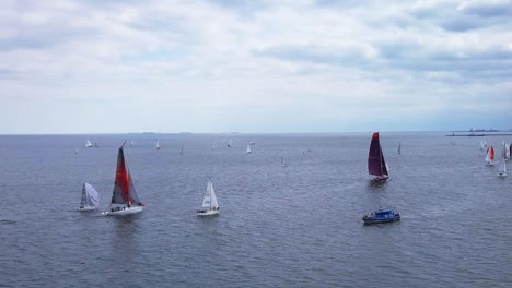 Aerial-View-Of-Sailboat-Regatta-In-A-Sea-Under-A-Cloudy-Sky