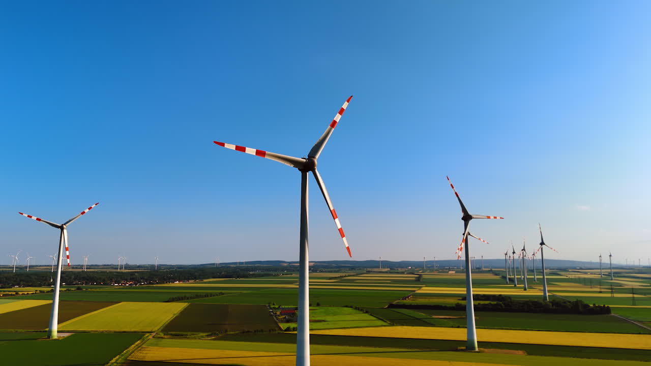 EU wind turbines produce clean energy. Wind turbines spin in a vast landscape, harnessing energy from strong winds under a clear blue sky