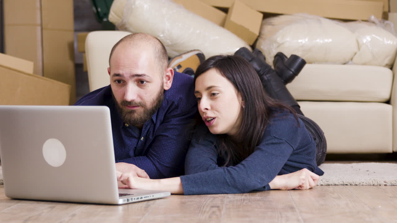Couple using laptop after moving in