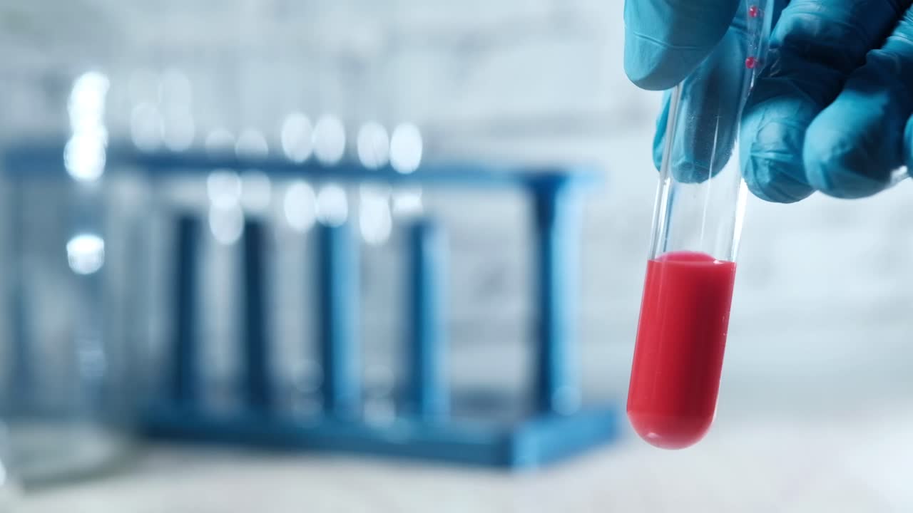 científico sosteniendo un tubo de ensayo con un líquido rojo