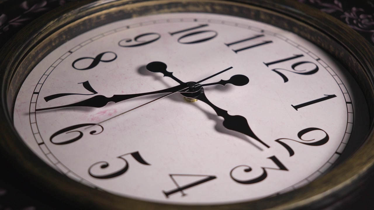 Timelapse static close up shot of a retro wall clock face. Black ornamental hands spin backwards quickly past numbers to show time passing or reversing.
