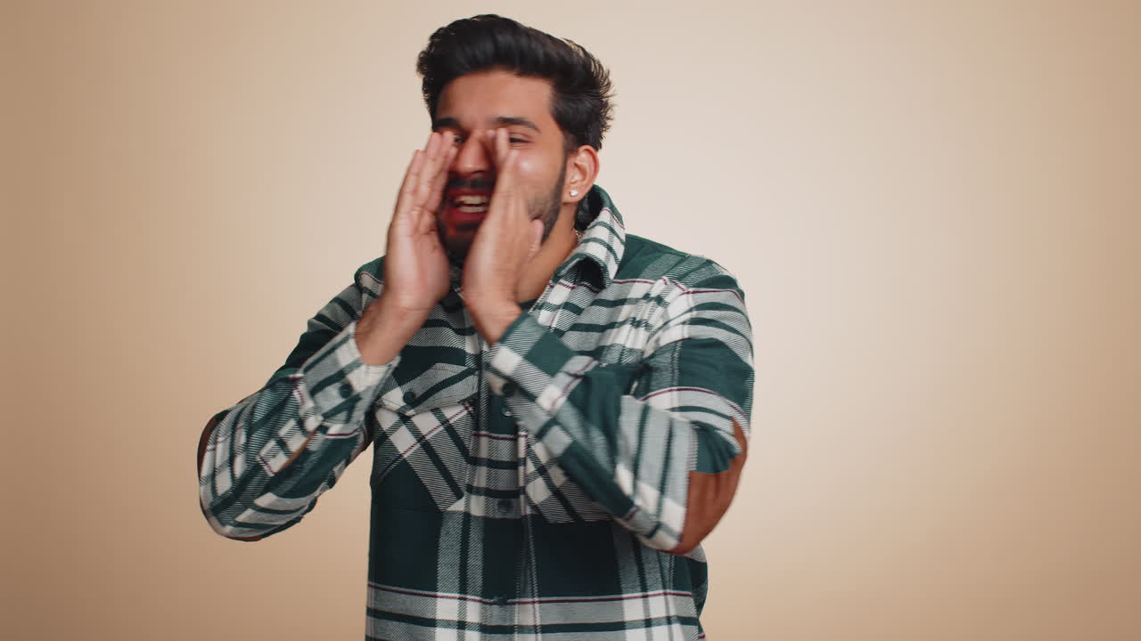 Indian handsome man scream yell with hand near mouth greeting hello announces the news salesman