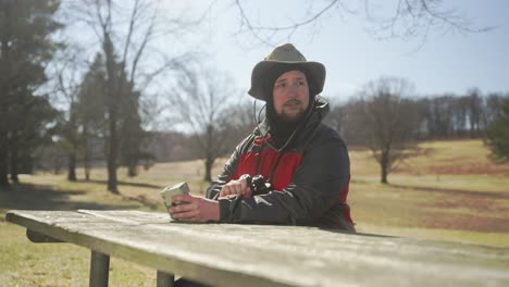 hombre en la naturaleza tomando fotografías y mirando con sus binoculares