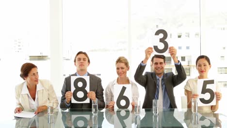 interview panel holding up scores and smiling