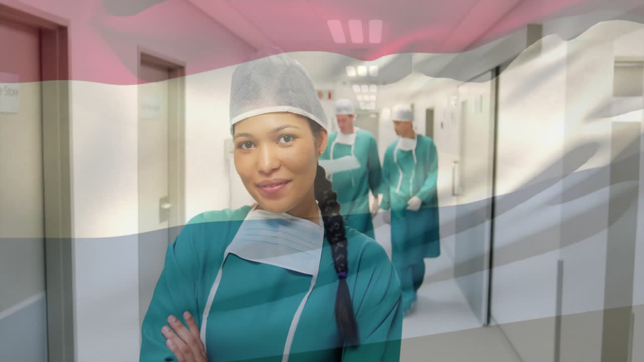 Animation of flag of netherlands over diverse surgeons walking and smiling with face mask