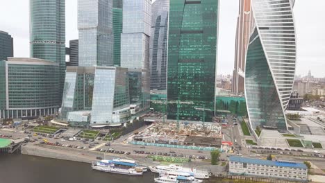 moscow city skyline with construction site and river boats