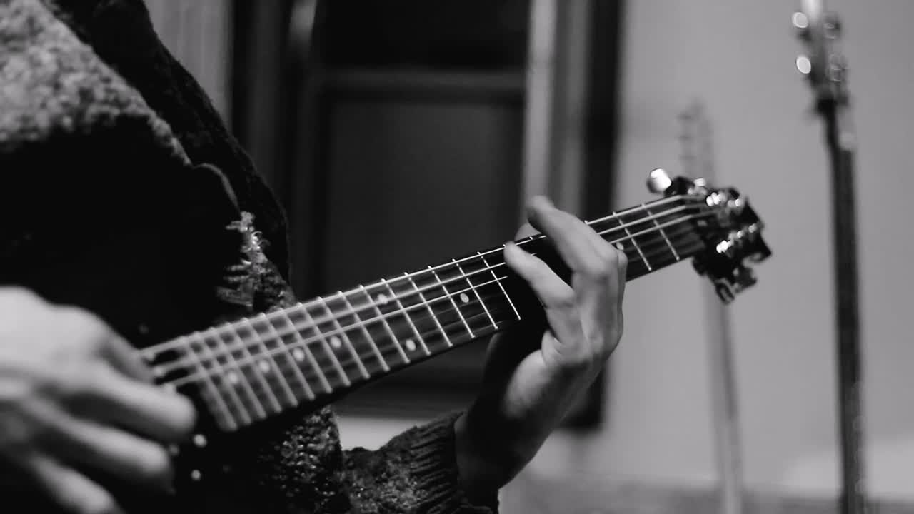 uomo che suona la chitarra elettrica con un pick su sfondo bianco