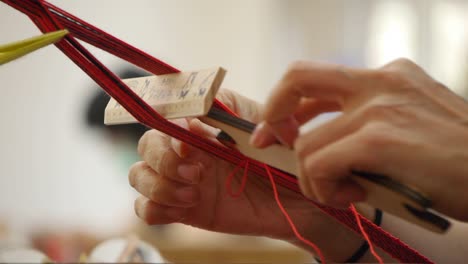 Fingers-and-hands-of-person-threading-yarn-and