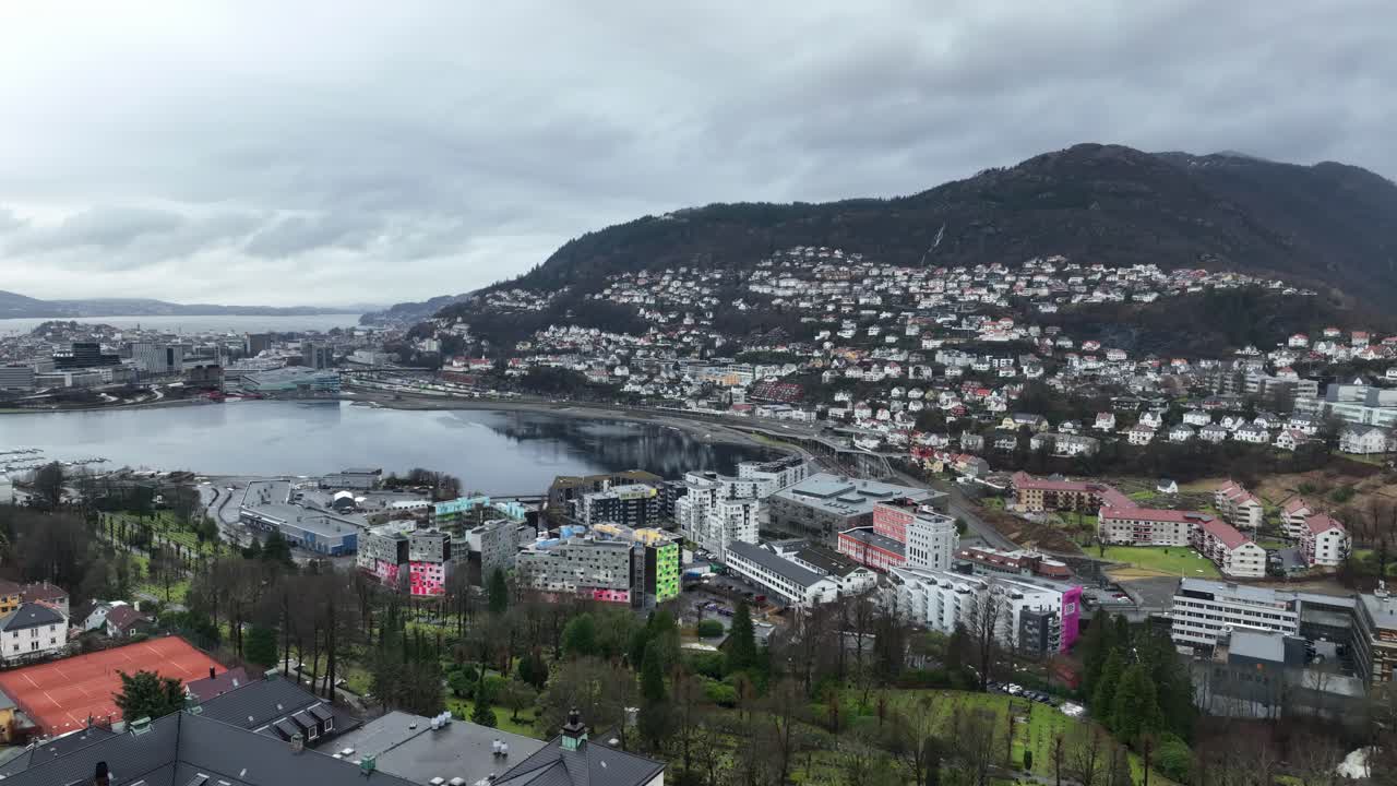 Rising aerial over Bergen, Norway, facing Big Lungegard, Sandviken, Floyen Mountain, Haukelandsbakken, Mollendal, Kalfaret, and Starefossen. Misty winter day, no snow