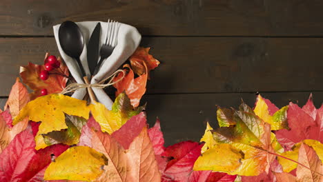 Animation-of-autumn-leaves-over-thanksgiving-dinner-place-setting-background