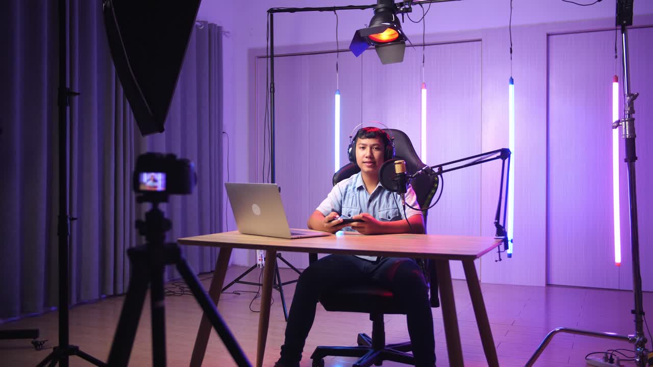 Asian Kid Boy Playing Video Game With Mobile Phone Then Smiles To Camera While Live Stream, Professional Light Equipment