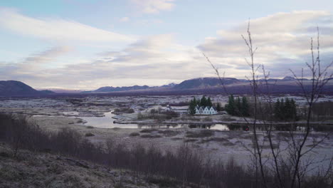 pan down from blue skies in a small town near reykjavik, iceland with mountains in the background