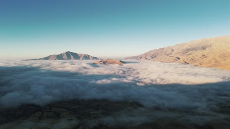 a mesmerizing aerial view of clouds blanketing a valley in the andes mountains during a sunny morning