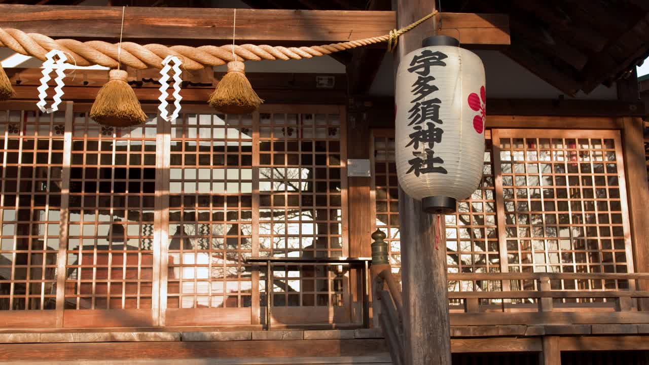 Statisk mellembillede af en træ Shinto-helligdomsbygning under varmt eftermiddagssolskin i Kanazawa