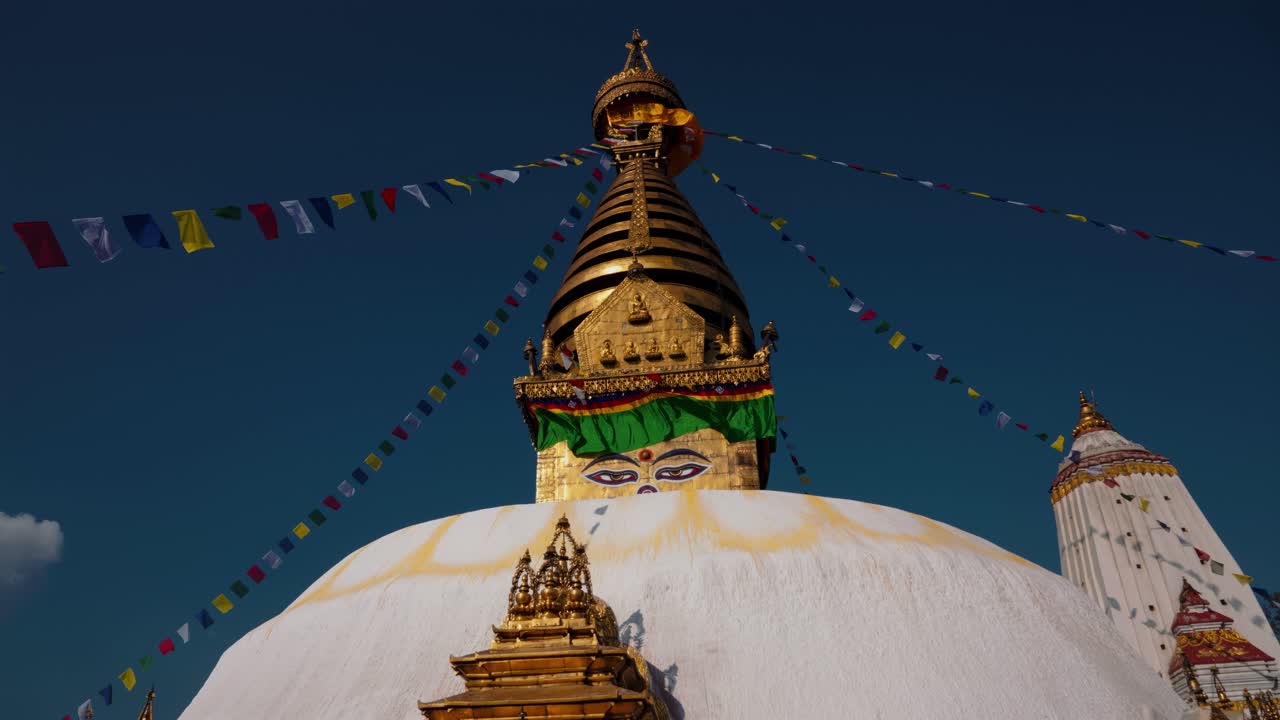 Swayambhun stupa, apintemppeli, Kathmandu, Nepal. Buddhan silmät, kultainen kupoli ja värikkäät rukousliput.
