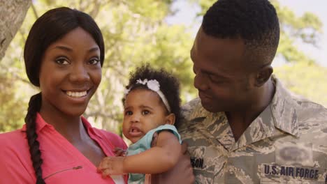 portrait of american soldier is smiling with his wife and their baby