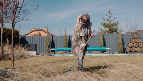 woman raking leaves in a backyard