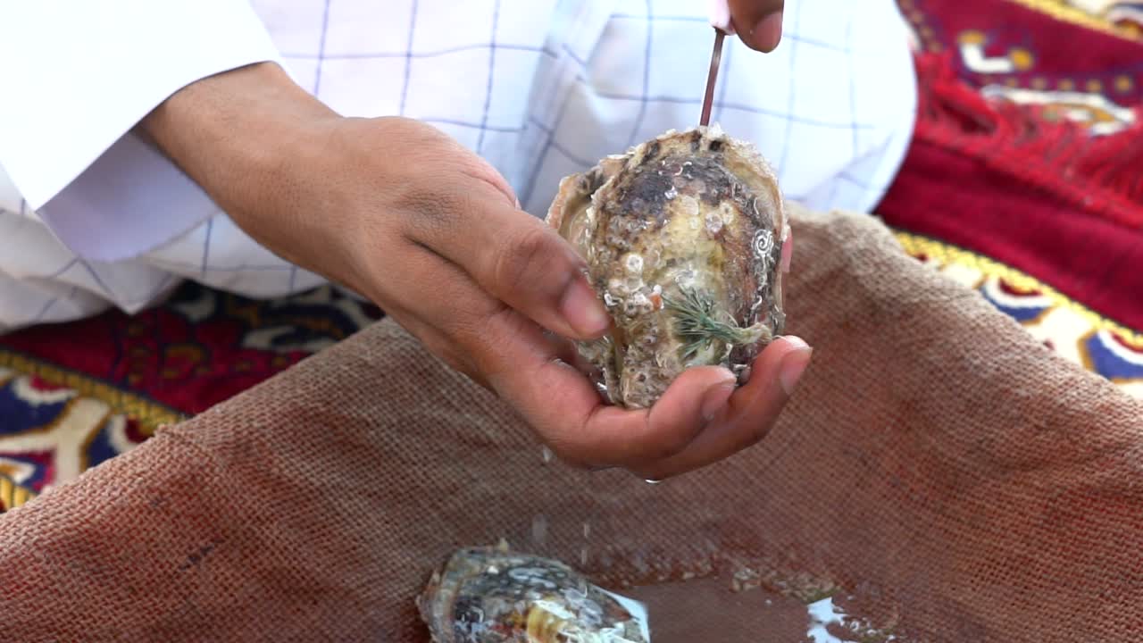 ajman 아랍 에미레이트에서 진주 굴을 여는 남자