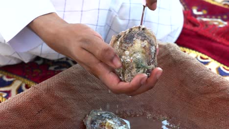 hombre abriendo ostra perla en ajman, emirato árabe unido