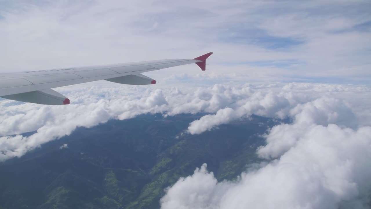 Airplane flight. Wing of an airplane flying above the clouds. View from the window of the plane. Aircraft. Traveling. 4K UHD video footage. 3840X2160