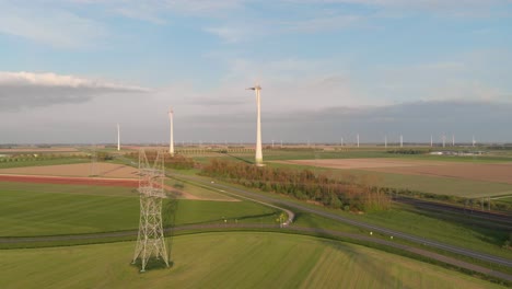 view of traffic along wind farm with rotating turbines in flevoland, netherlands