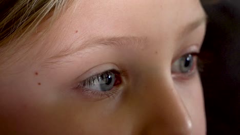 close up child's eyes watch electronic screen, wide eyes and raised eyebrows