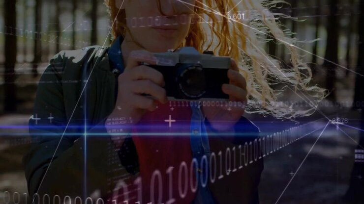Woman photographer lifting camera in park for taking shot with binary technology overlay sweeping