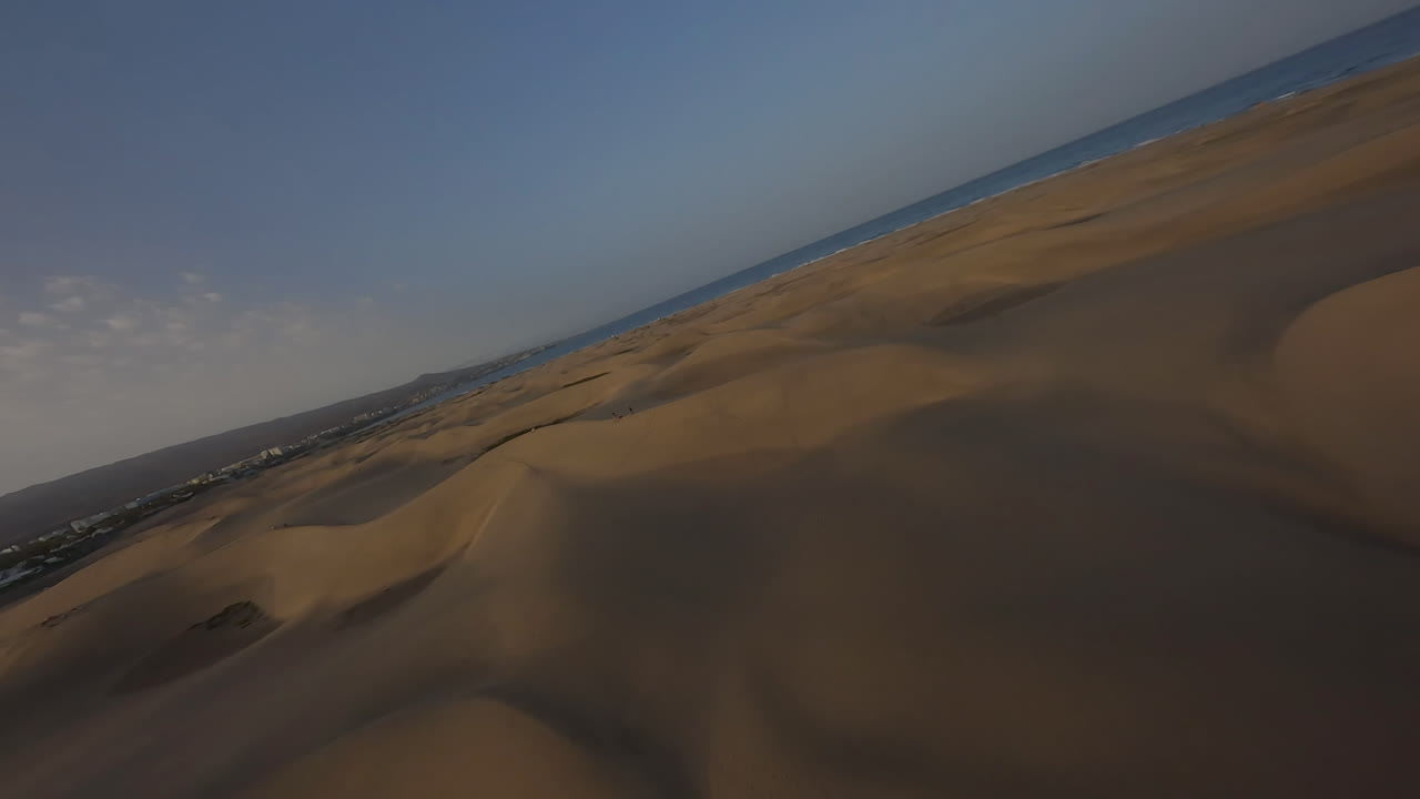 drone fpv volador sobre dunas de arena al atardecer, maspalomas
