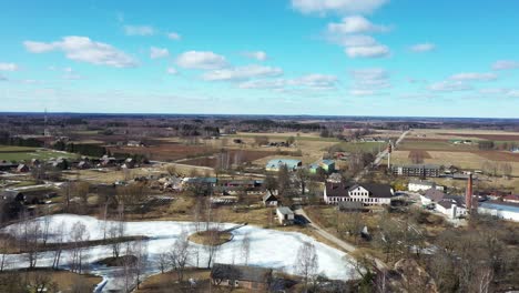 aerial birds eye view flying over rural town in summer, wide angle