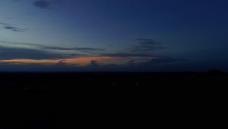 Luftaufnahmen-Für-Die-Blaue-Stunde-Während-Des-Sonnenuntergangs,-Die-Die-Lichter-Der-Stadt-Und-Eine-Autobahn-Zeigen