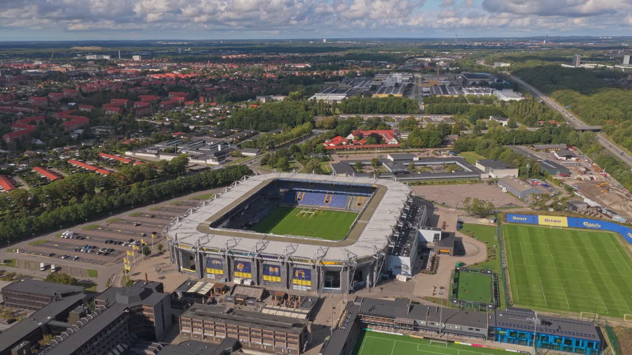 Scena z lotu ptaka nad stadionem piłkarskim Brøndby w Danii, z jasną murawą.