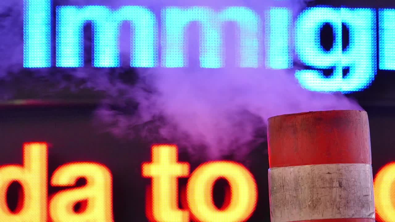 Smoke rising from a pipe near a glowing billboard