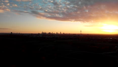 Langsam-über-Felder-Hinab,-Während-Die-Skyline-In-Der-Ferne-Verschwindet