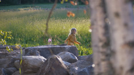 Scene-of-Young-happy-summer-girl-running-on-a-meadow-at-sunset,-tracking-side-shot-slow-motion