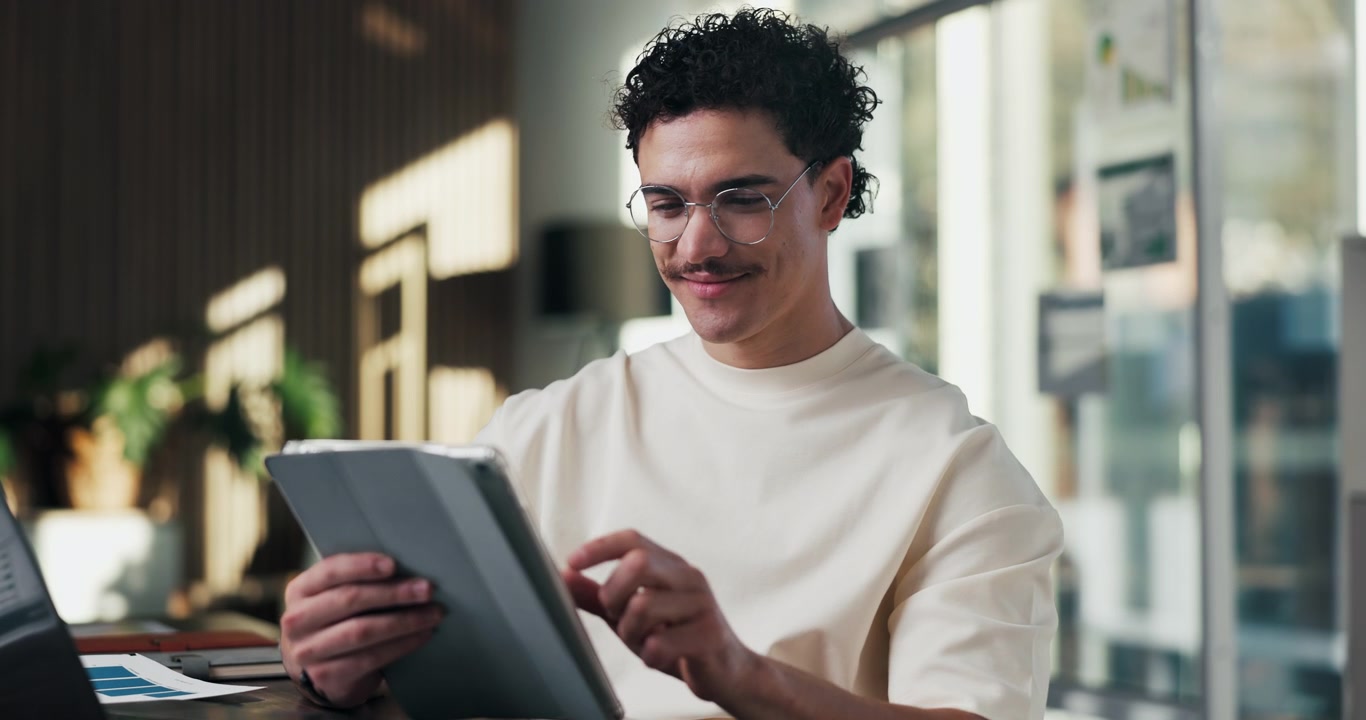 Young Man Using a Digital Tablet in a Modern Office