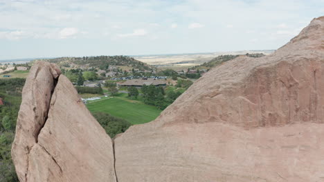campo de golf de punta de flecha en littleton colorado con césped verde, rocas rojas y cielos azules