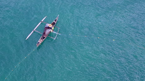 Fotografía-Cenital-De-Un-Hombre-Pescando-En-Un-Pequeño-Dhow-Pesquero-En-El-Océano-Índico-Cerca-De-Madagascar