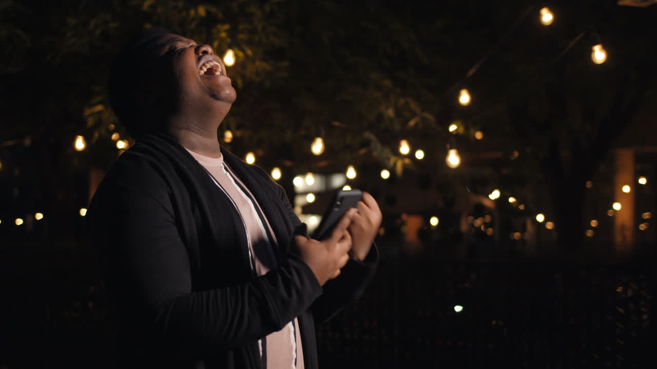 Person celebrating success at night with lights