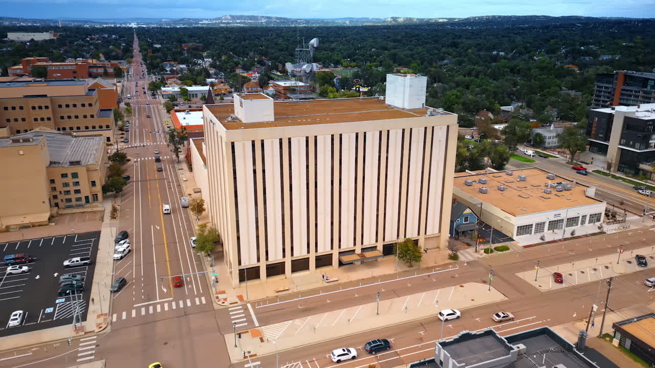 Colorado Springs, USA, 22 July 2025: Approaching the multi-storied building in the cityscape of Colorado Springs, Colorado, USA. Low-rise green city area at backdrop