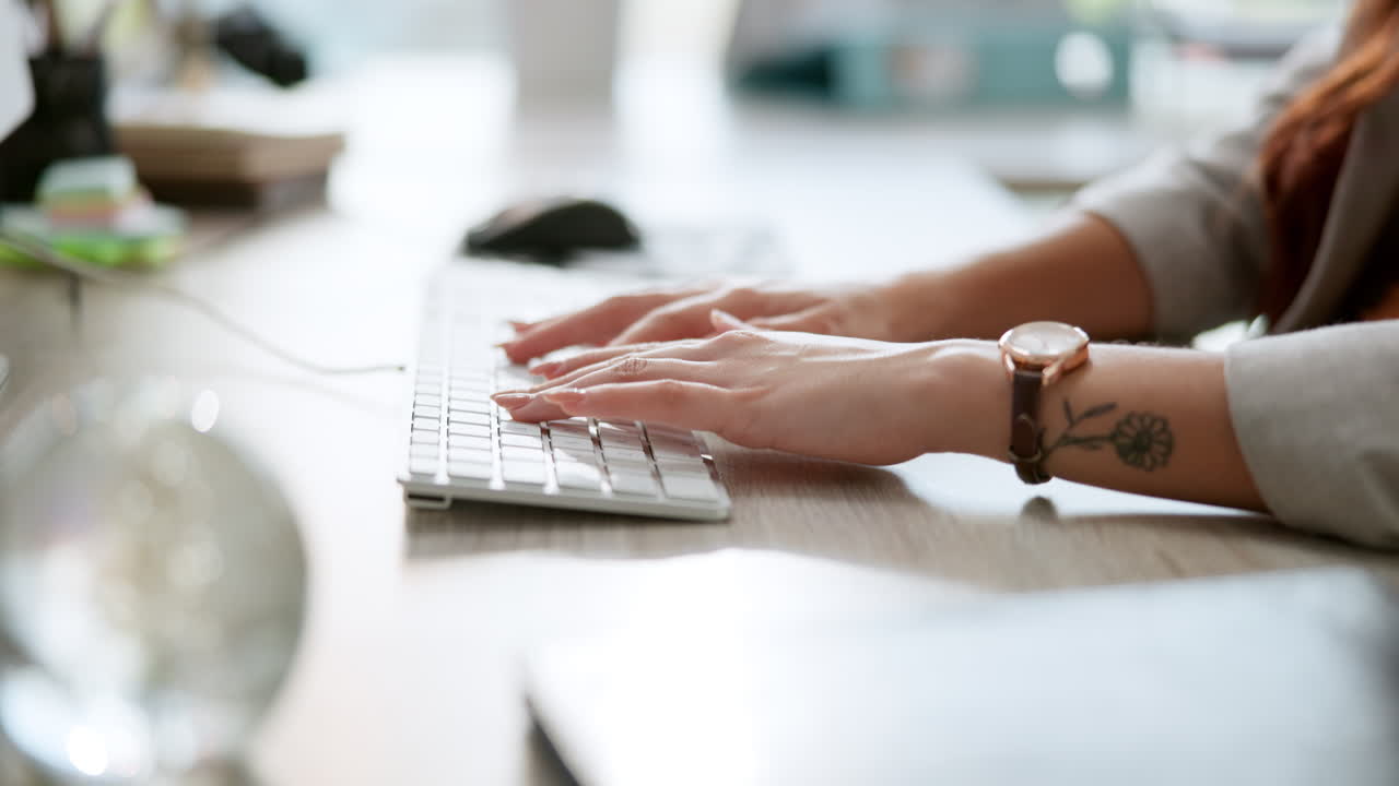 Hands typing on a computer keyboard