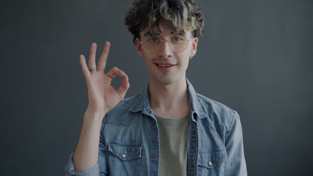 Young Man Smiling and Making an Ok Sign