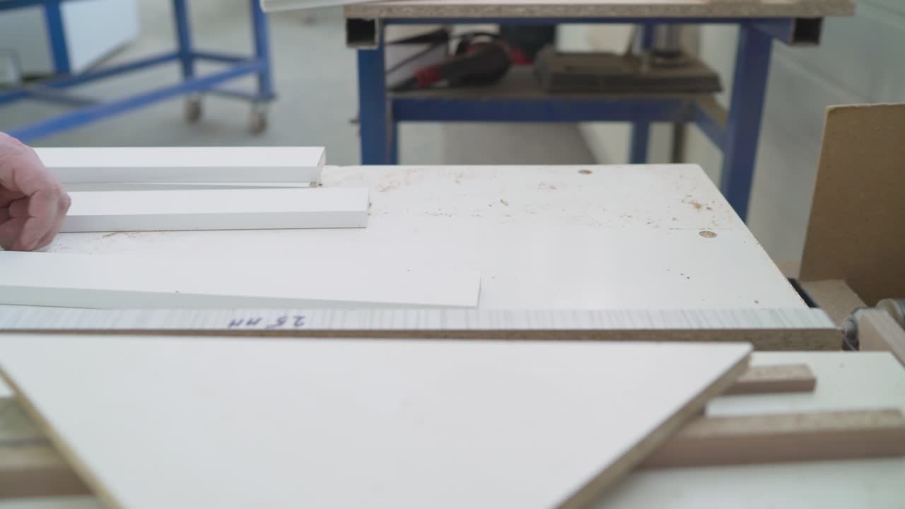 los espacios en blanco de los muebles antes de aplicar la película. fabricación de muebles. espacios en blanco para muebles de madera están en la máquina. industria del trabajo de la madera. taller de muebles un taller para la producción de productos de madera.