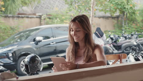 woman using tablet in street cafe